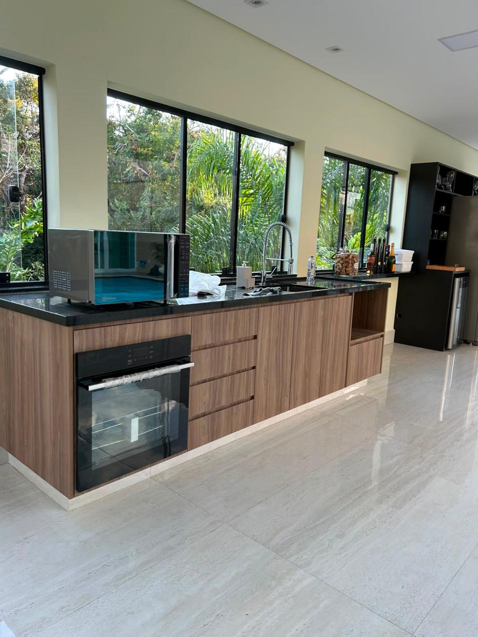 Cozinha planejada em madeira e preto, produzida pela PH Ambientes